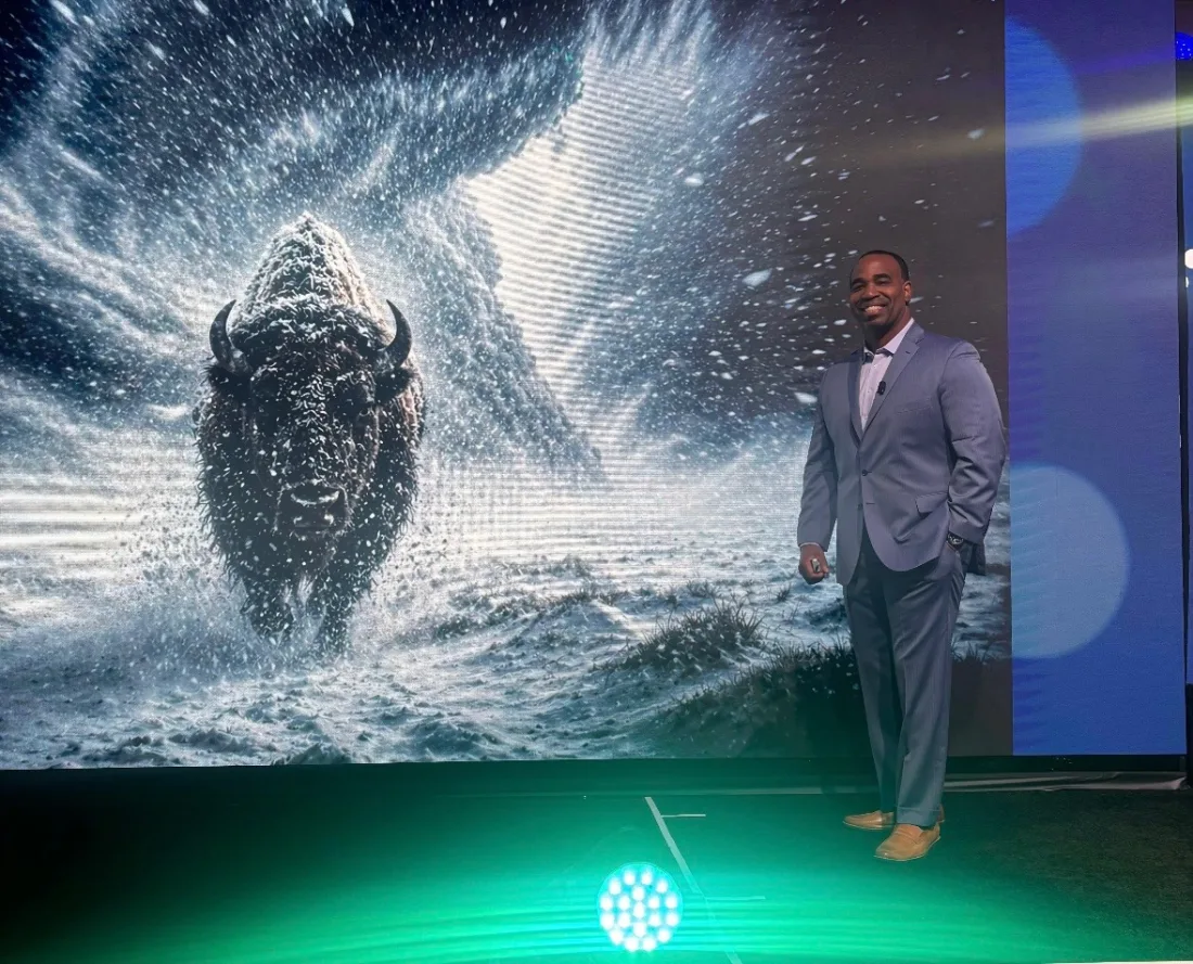 Marques Ogden on stage beside a bison backdrop